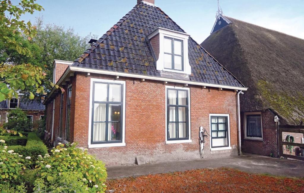 an old brick house with a thatched roof at Pet Friendly Apartment In Paesens With Wifi in Paesens