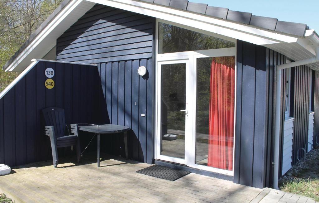 a black shed with a table and a glass door at Schmugglerstieg 13b - Dorf 5 in Travemünde