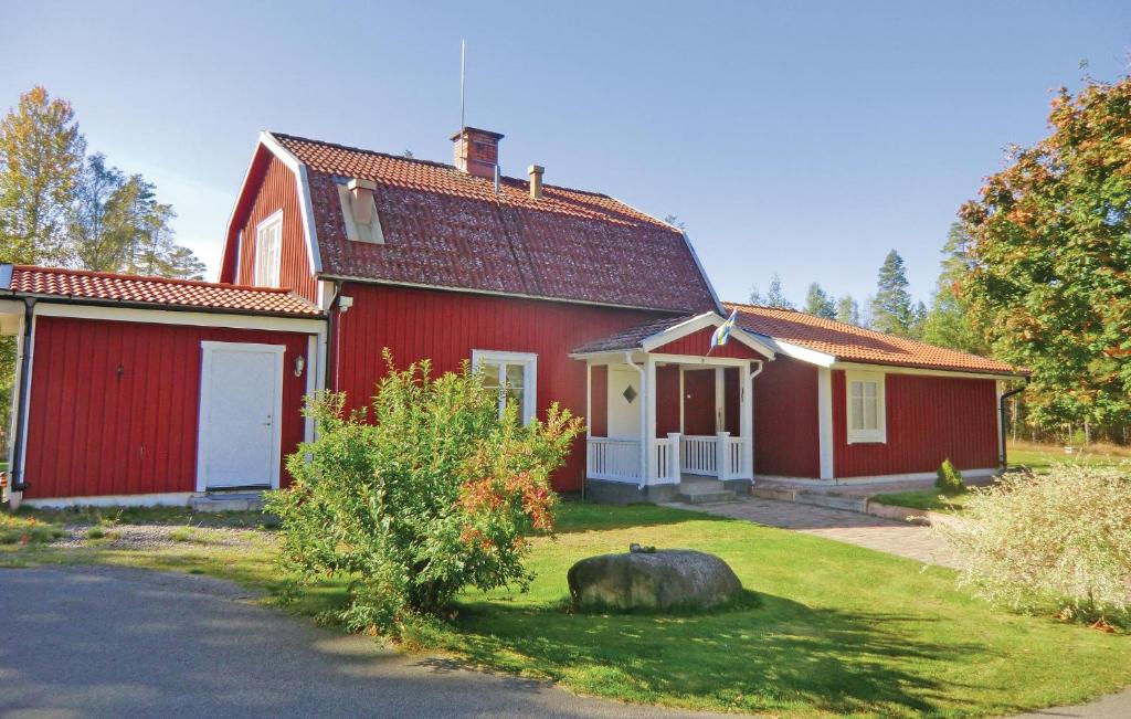 uma casa vermelha com um grande animal no quintal em Beautiful Home In Orrefors With Lake View em Orrefors