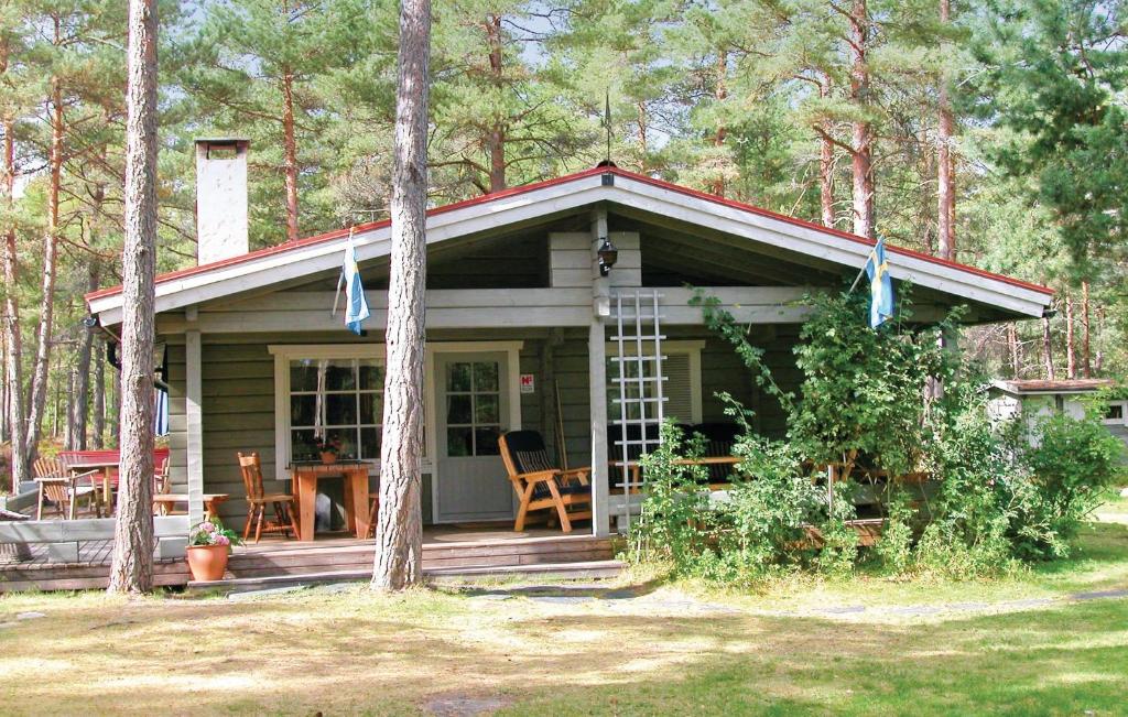 een kleine hut in het bos met een tafel en stoelen bij Cozy Home In Hammar With Sauna in Hammarö