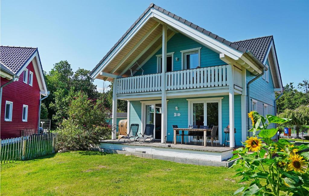 uma casa azul com uma mesa no jardim da frente em Seeliebe 3 em Süssau