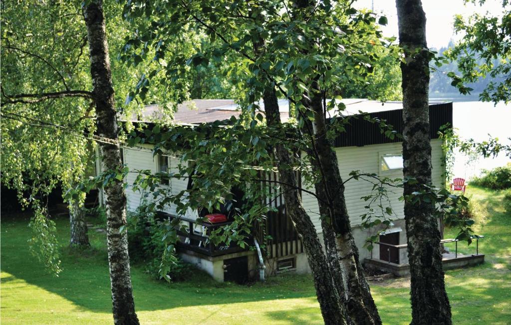 Amazing home in Sparreholm with 5 Bedrooms, Sauna and WiFi في Sparreholm: بيت ابيض وامامه اشجار