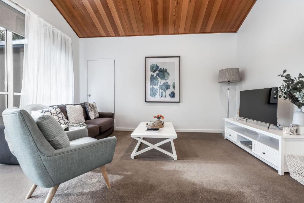 a living room with a couch and a tv at Sails Five Inverloch in Inverloch