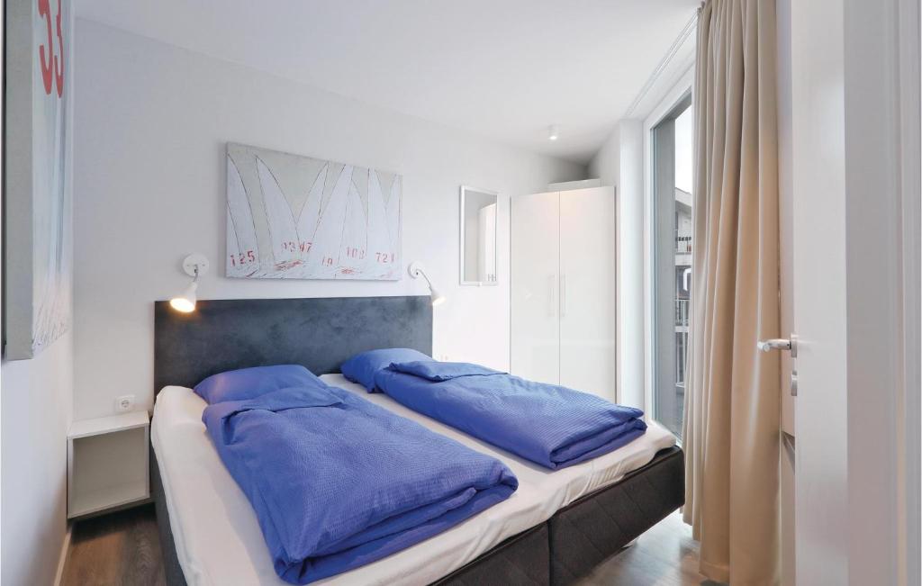 a bedroom with a bed with blue pillows on it at Dnenvilla Deluxe in Priwall