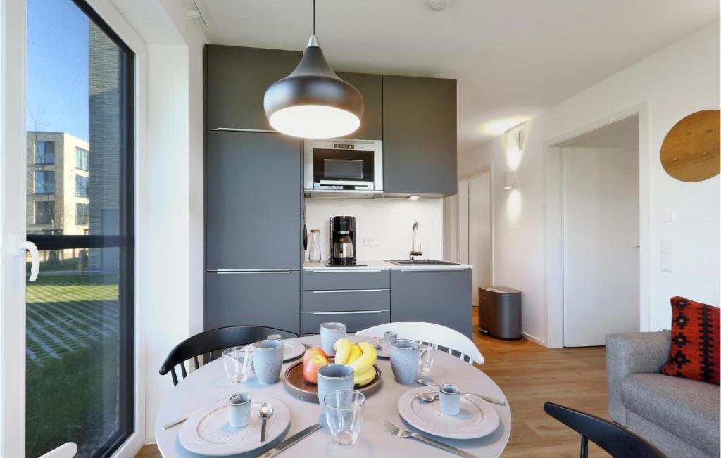 ein Esszimmer mit einem Tisch und einer Küche in der Unterkunft Gorgeous Apartment In Lembruch-dmmer See With Kitchen in Lembruch