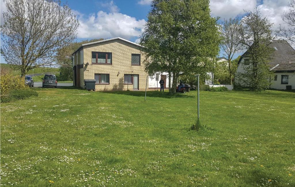 una casa in un giardino con un albero nell'erba di Awesome Apartment In Hedwigenkoog With Kitchen a Hedwigenkoog