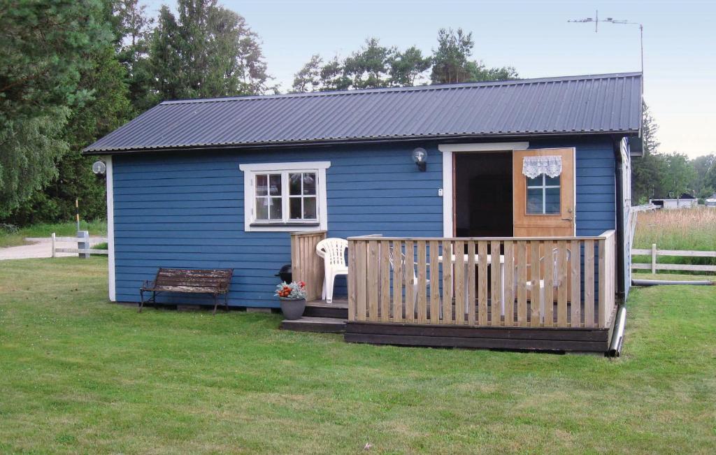 een blauw tiny house met een veranda en een bank bij Cozy Home In Visby With Wifi in Visby