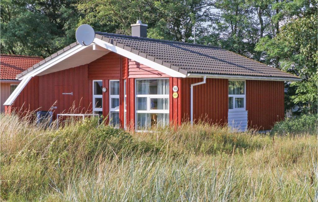 a red house with a white door in a field at Freibeuterweg 10 - Dorf 6 in Priwall