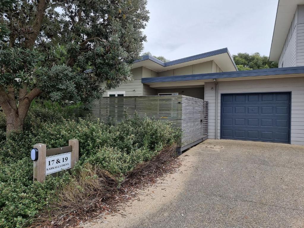 a house with a sign in front of a garage at One Level at Broadbeach Inverloch in Inverloch