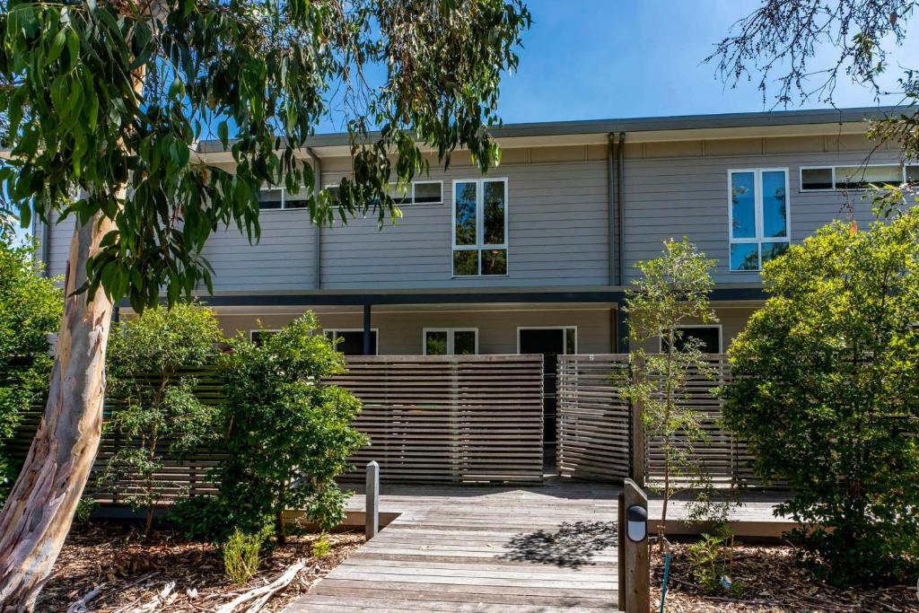 een gebouw met een houten hek ervoor bij Coastal Soul Villa at Broadbeach in Inverloch