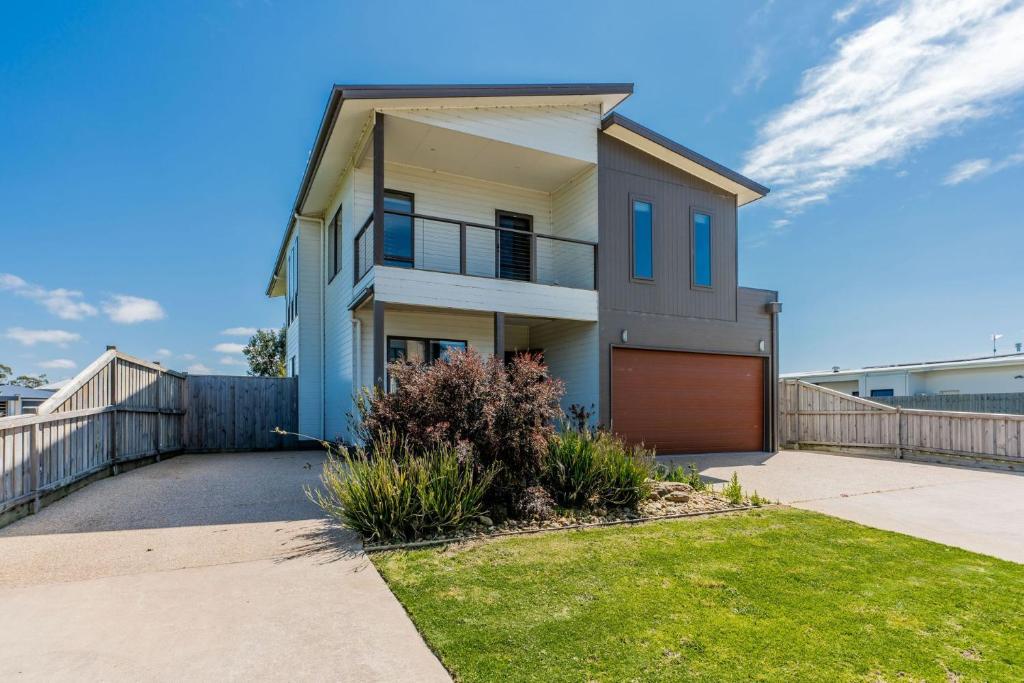 a house with a driveway and a fence at Surfside Lakeviews Free Wifi in Inverloch