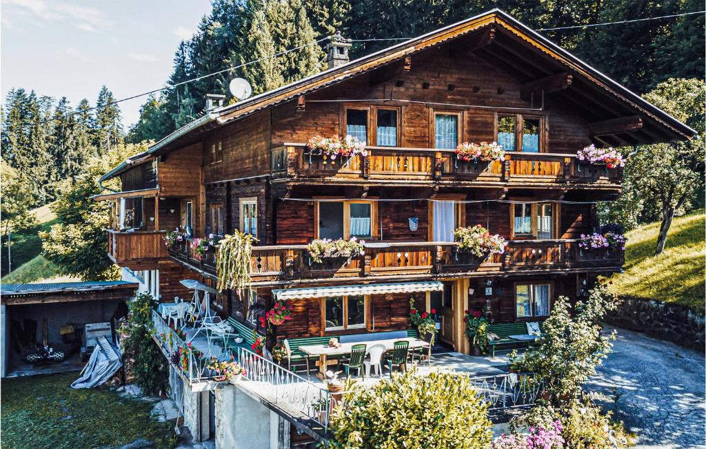 una casa di tronchi con fiori sui balconi di 5 Bedroom Awesome Home In Hart Im Zillertal a Hart im Zillertal