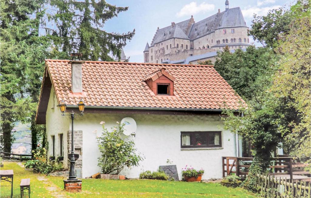 una pequeña casa blanca con un castillo en el fondo en Gorgeous Home In Vianden With Wifi, en Vianden