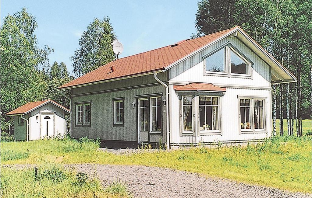 a small green and white house in a field at Holiday Home Östra Berga Lysvik in Lysvik