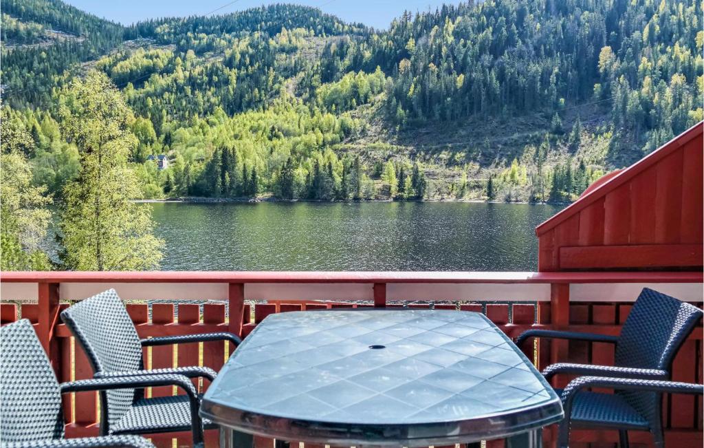 a table and chairs on a balcony with a view of a lake at Heggebu in Vråliosen