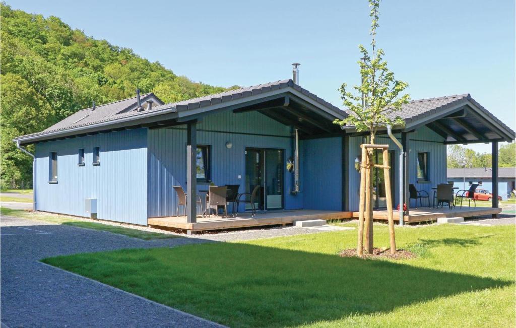 ein kleines blau-weißes Haus mit einem Baum in der Unterkunft Ferienhausdorf Thale in Thale