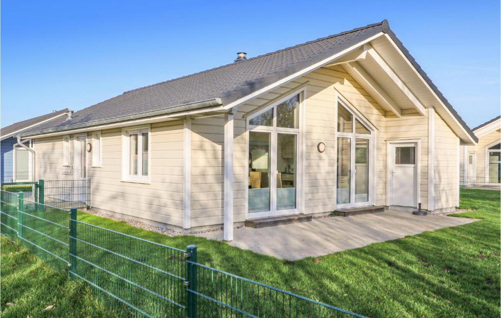 ein Haus mit einem Zaun davor in der Unterkunft Beautiful Home In Dagebll With 2 Bedrooms, Sauna And Wifi in Dagebüll