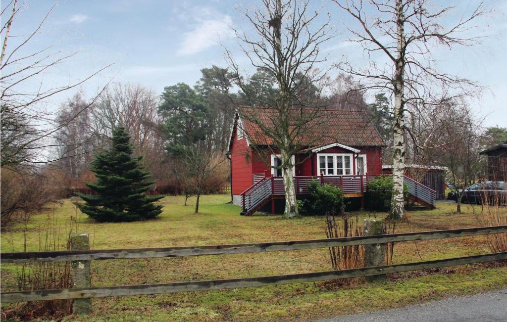 une maison rouge avec une clôture devant elle dans l'établissement Amazing Home In Slvesborg With Kitchen, à Sölvesborg