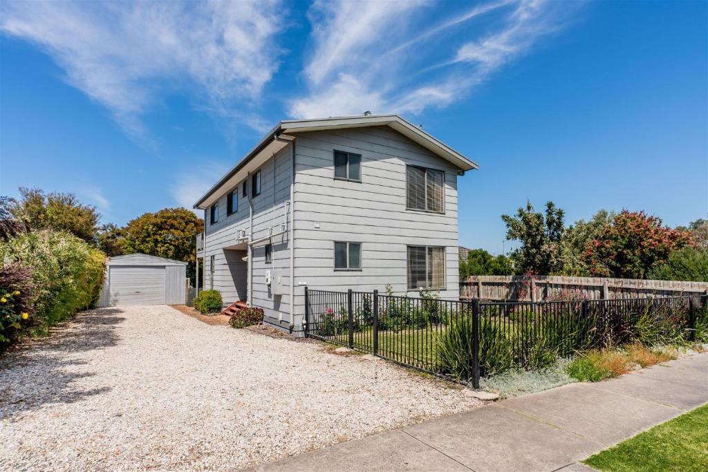 a white house with a fence in front of it at EAGLES NEST VIEWS ON TAMARA in Inverloch