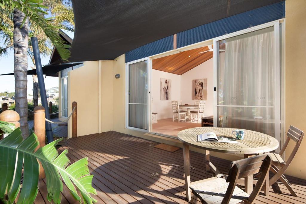 a patio with a table and chairs on a deck at Sails Two Inverloch in Inverloch