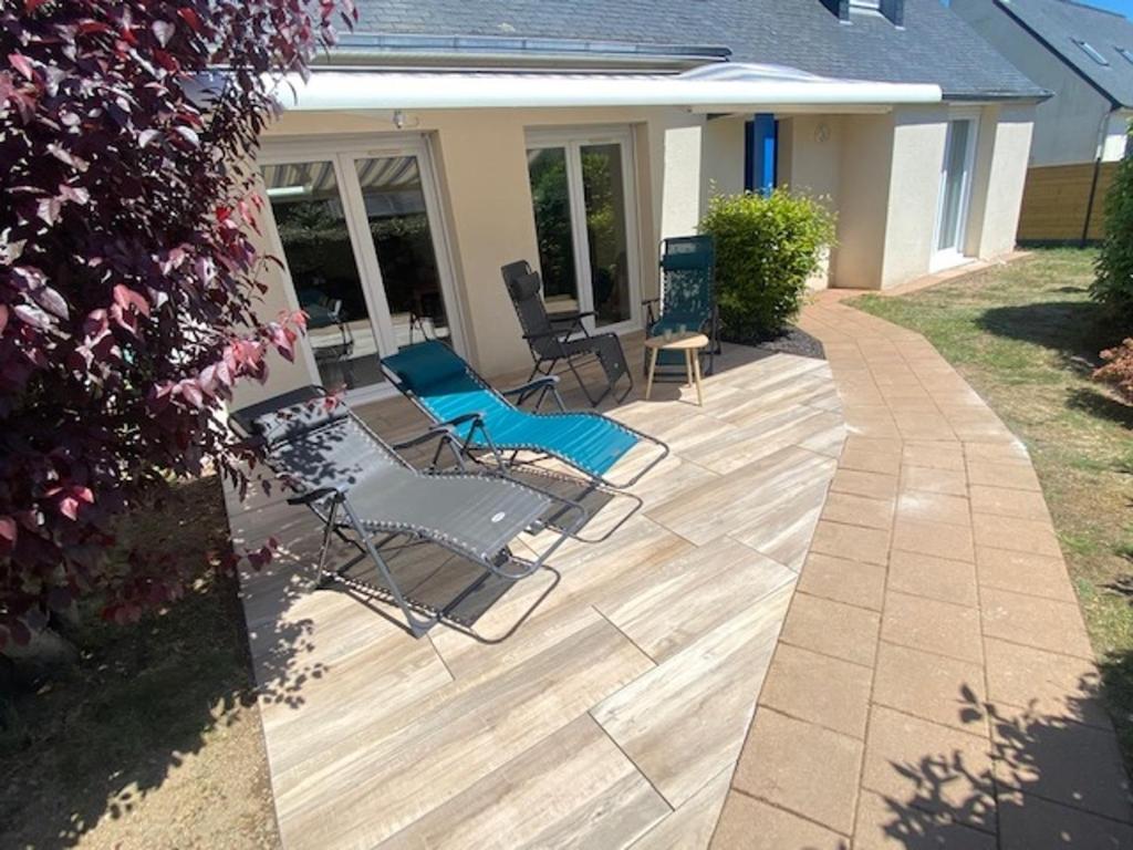 a patio with chairs and a table on a house at Maison charmante proches plages - 9 pers. - jardin, vélos, calme - Arzon - FR-1-639-22 in Arzon