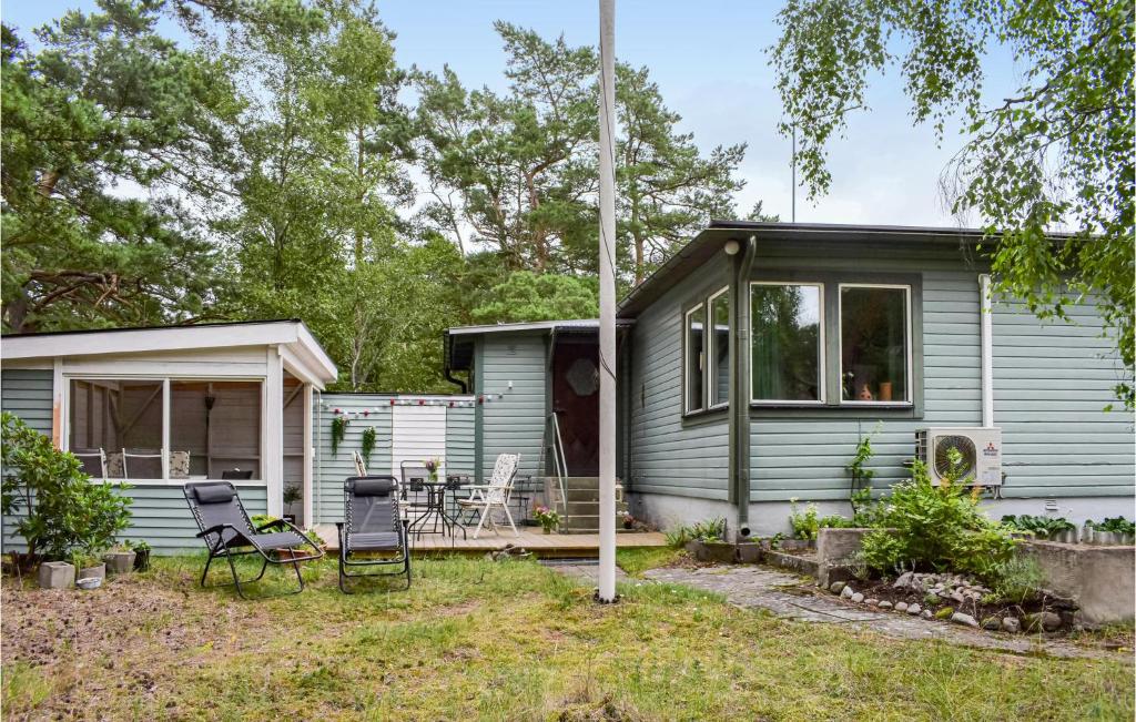 a green tiny house with a porch and chairs at Holiday Home Yngsjö 49 in Yngsjö