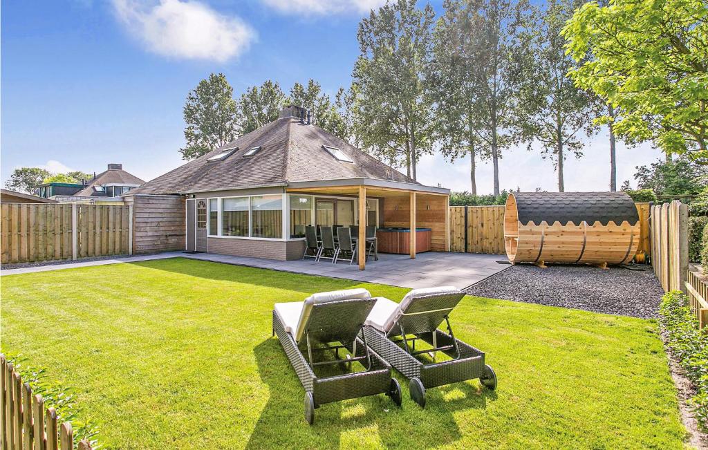 a yard with two chairs and a house at Oud Kempen Bungalow 37 in Stavenisse