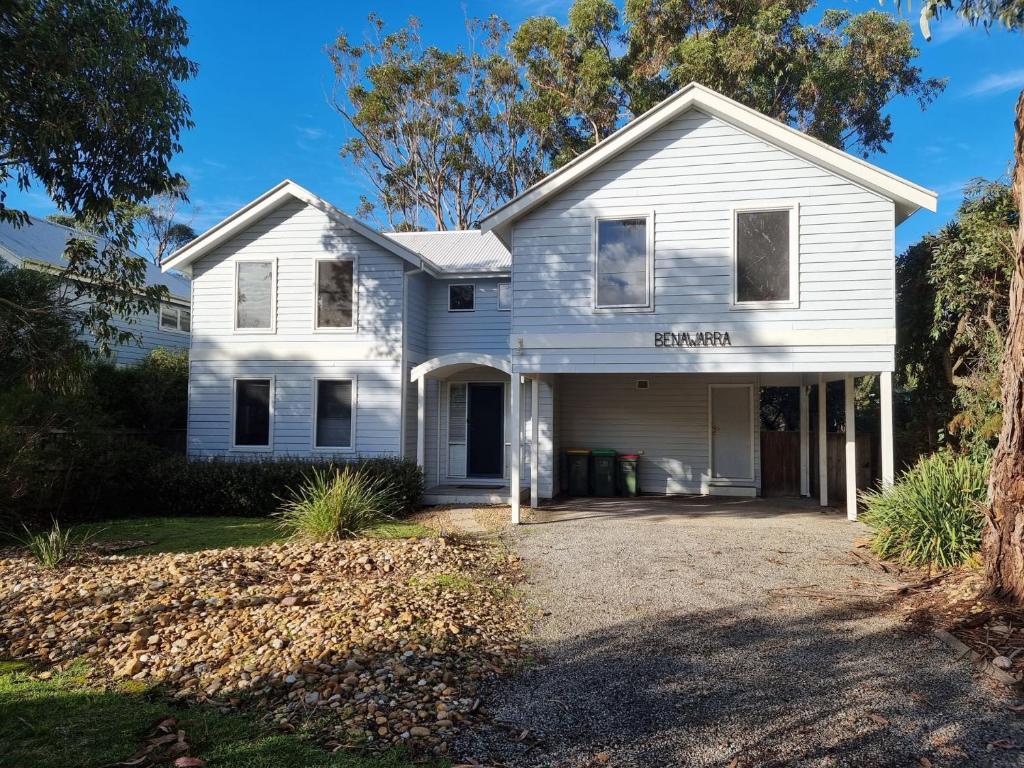 a white house with a driveway at Evergreen Beach House in Inverloch