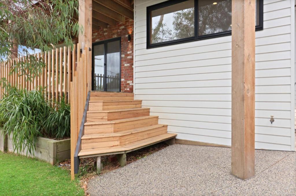 a house with wooden stairs on the side of it at Coastal Beauty on Bruce in Inverloch