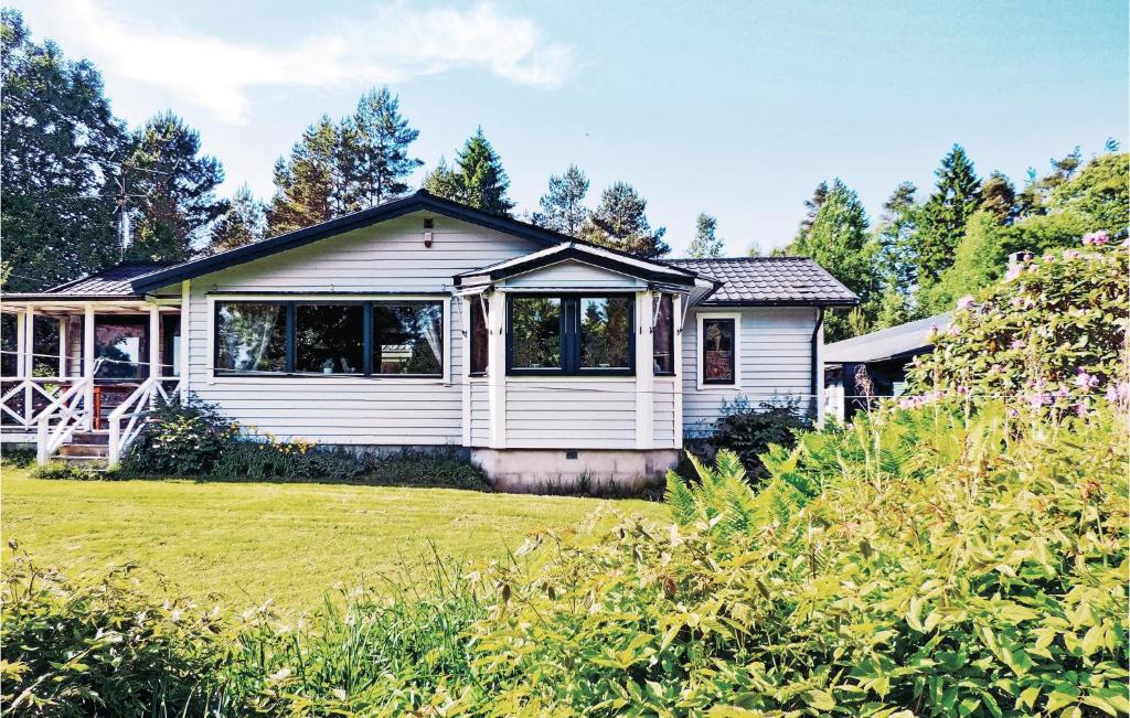 ein weißes Haus mit einer Veranda und einem Hof in der Unterkunft Pet Friendly Home In Laholm With Kitchen in Plingshult