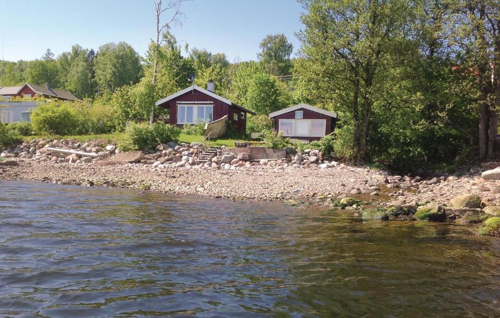 a group of cottages on the shore of a river at Amazing Home In Stre With Kitchen in Storsand