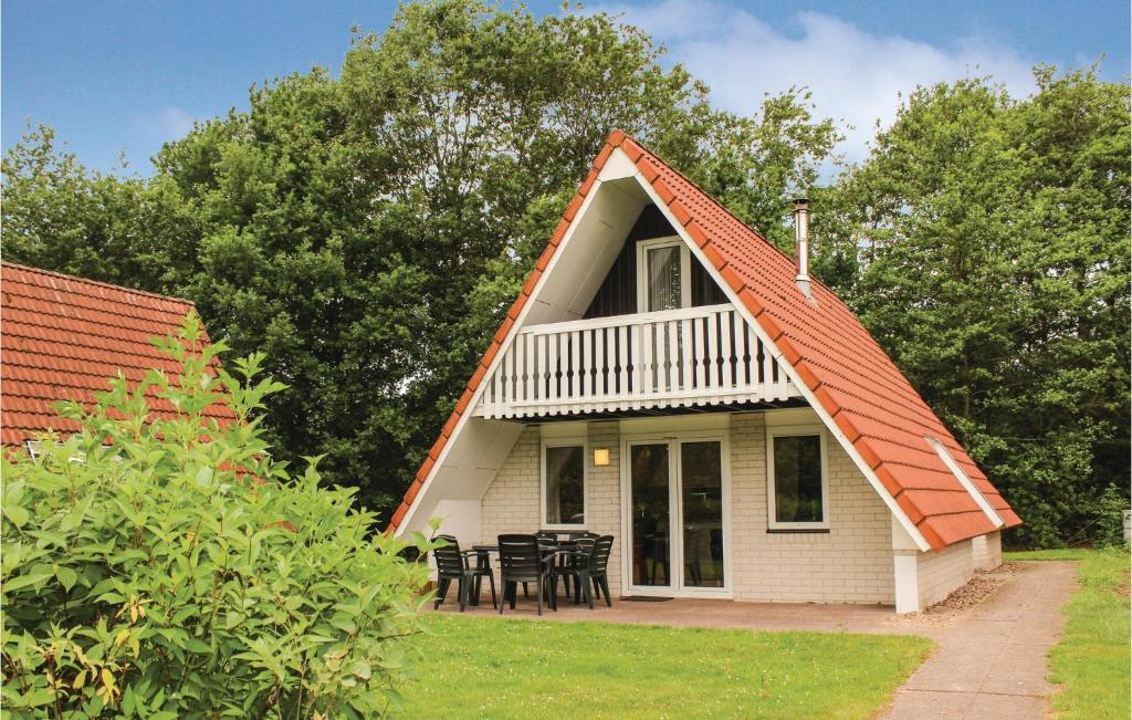 een klein wit huisje met een rood dak bij Nice Home In Gramsbergen With 3 Bedrooms, Wifi And Indoor Swimming Pool in Gramsbergen