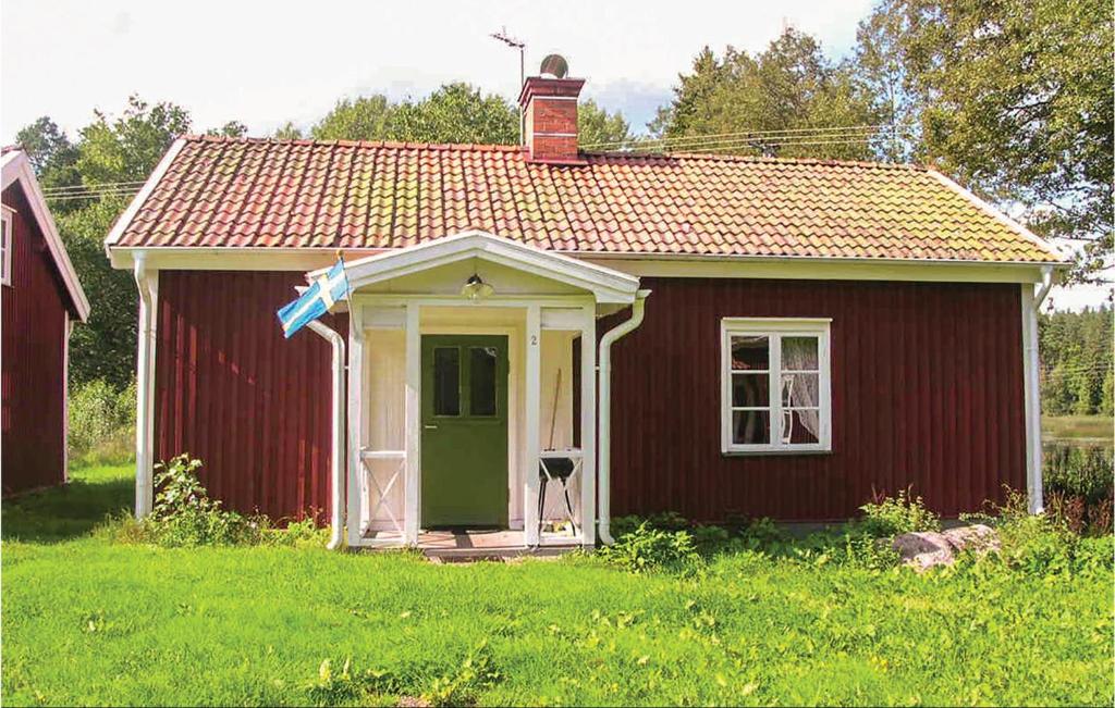 VimmerbyにあるAmazing Home In Vimmerby With Wifiの野原の緑の扉のある小さな赤い家