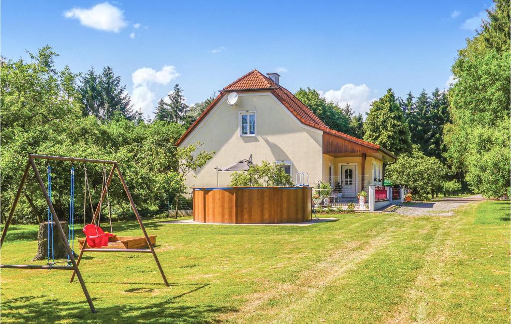 ein Haus mit einem Spielplatz davor in der Unterkunft Beautiful Home In Loipersdorf-kitzladen With Outdoor Swimming Pool in Kitzladen