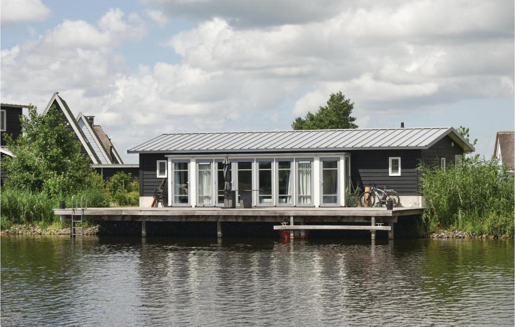 ein Haus auf einem Steg auf einem Wasserkörper in der Unterkunft Bodelaeke-Rietwoning in Giethoorn