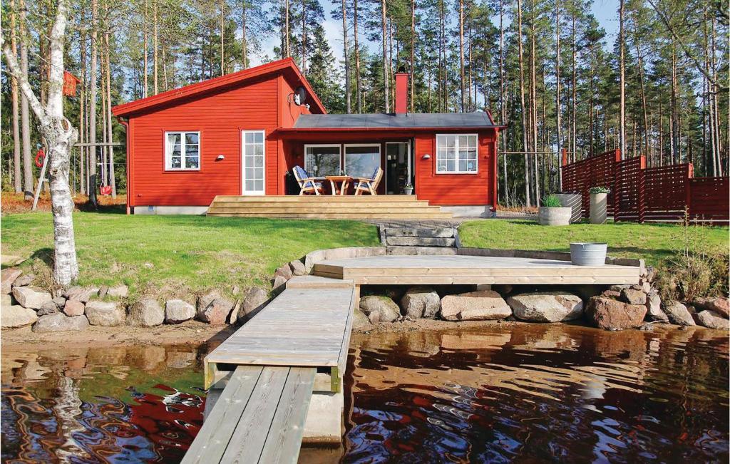 una cabina rossa con un molo e uno stagno di Lovely Home In Vaggeryd With House Sea View a Vaggeryd
