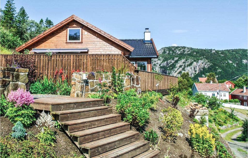 a house with a wooden staircase leading to a garden at Stunning Home In Farsund With 4 Bedrooms, Jacuzzi And Sauna in Herad