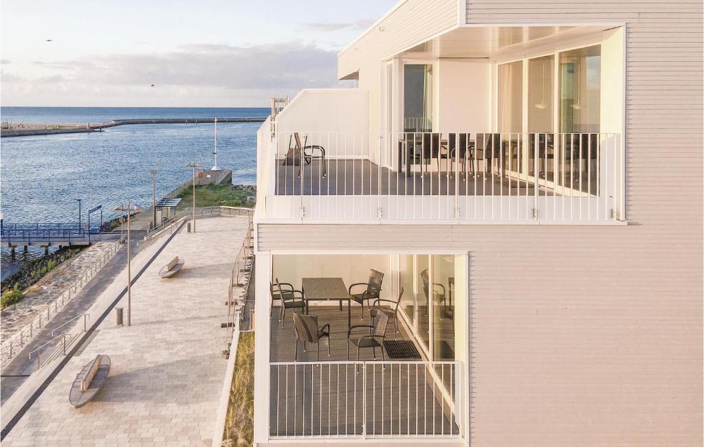 a white house with a balcony overlooking the ocean at Promenadenvilla in Travemünde