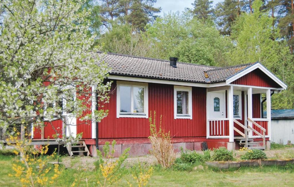 une maison rouge avec des garnitures blanches dans une cour dans l'établissement Cozy Home In Nossebro With Kitchen, à Lekåsa