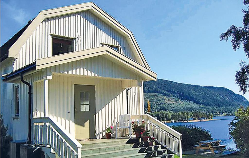 una casa con porche y escaleras junto a un lago en Amazing Home In Bygland With House Sea View, en Bygland