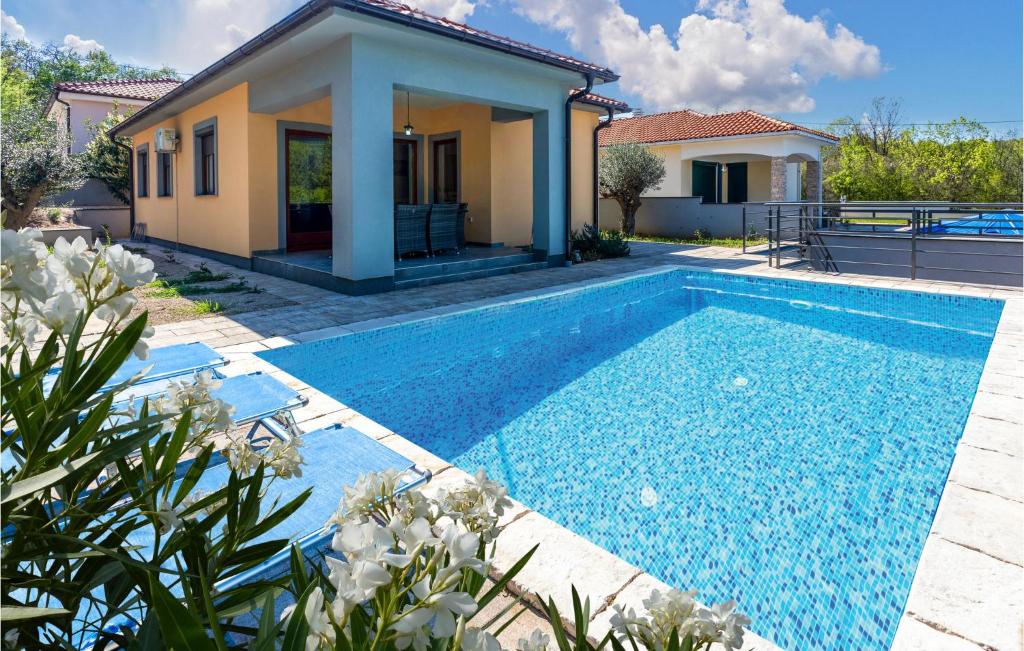 a swimming pool in front of a house at Beautiful Home In Gostinjac With Outdoor Swimming Pool in Gostinjac