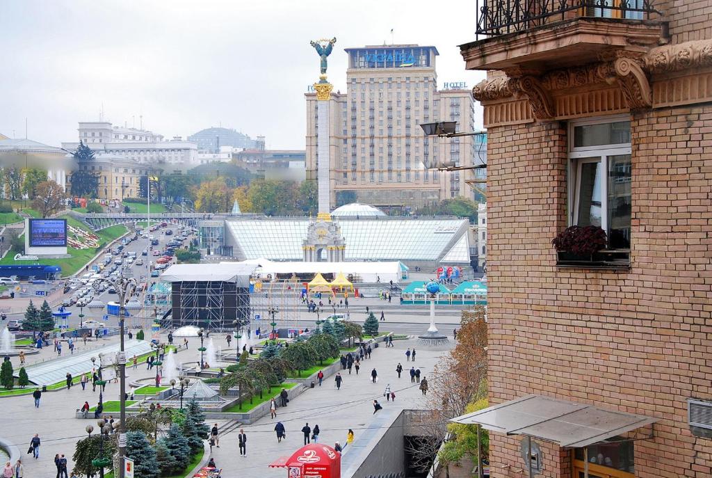 grupa ludzi spacerujących po ulicy miejskiej w obiekcie Apartments on Independence Square w Kijowie