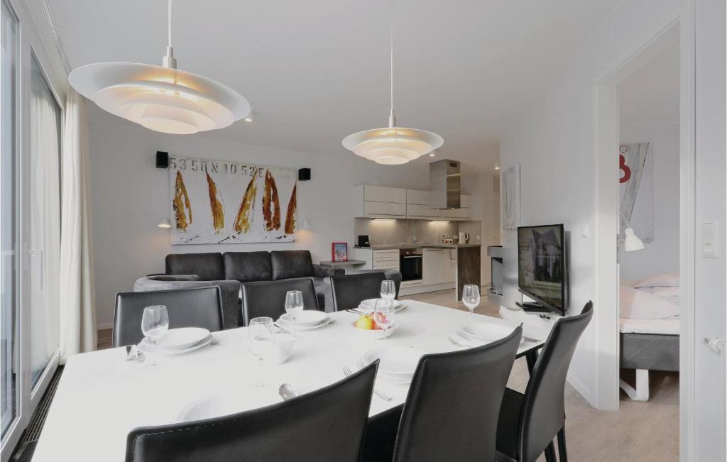 une salle à manger avec une table blanche et des chaises noires dans l'établissement Dnenvilla, à Travemünde