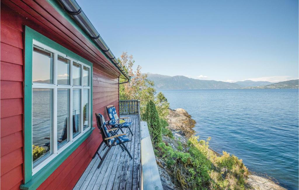 a house with a bench on a balcony with a view of the water at Amazing Home In Balestrand With 2 Bedrooms in Balestrand