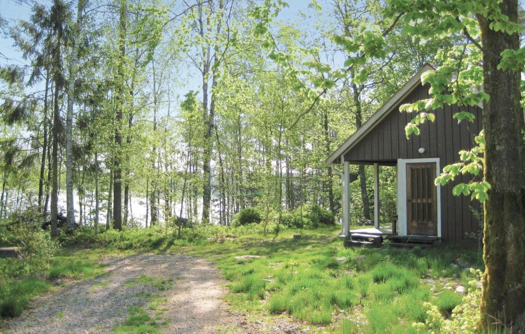 a small cabin in the woods with a dirt road at Beautiful Home In Torup With House Sea View in Ynnabo