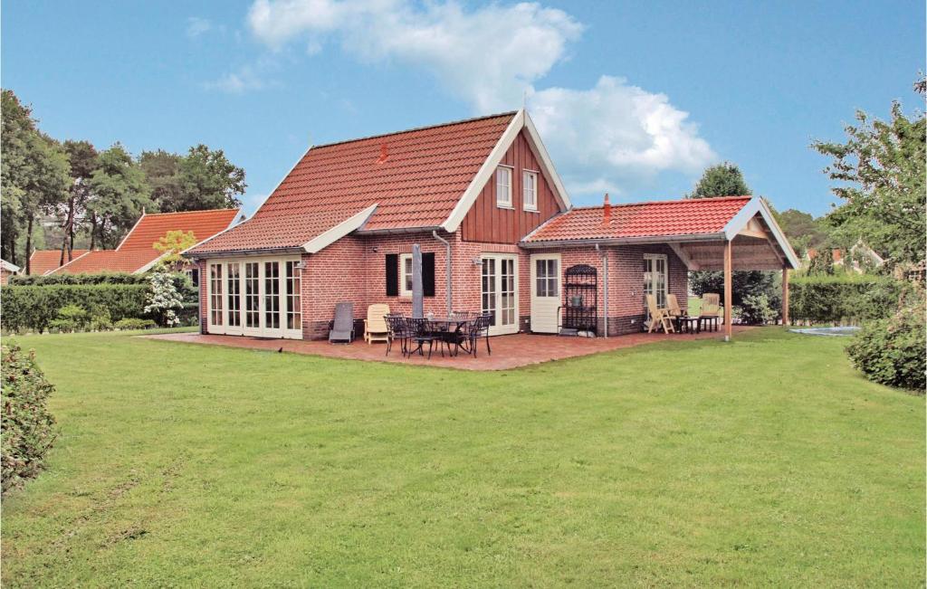 een rood bakstenen huis met een patio en een tuin bij Buitengoed Het Lageveld - 59 in Hoge-Hexel