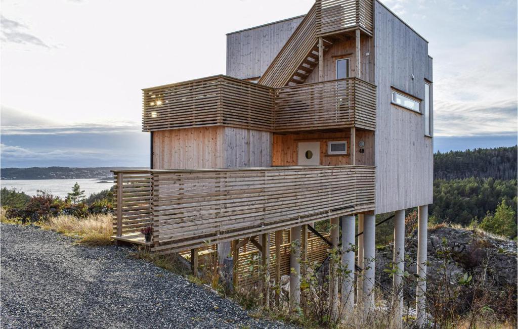 une maison en bois sur le flanc d'une colline dans l'établissement Cozy Home In Sndeled With House Sea View, à Søndeled