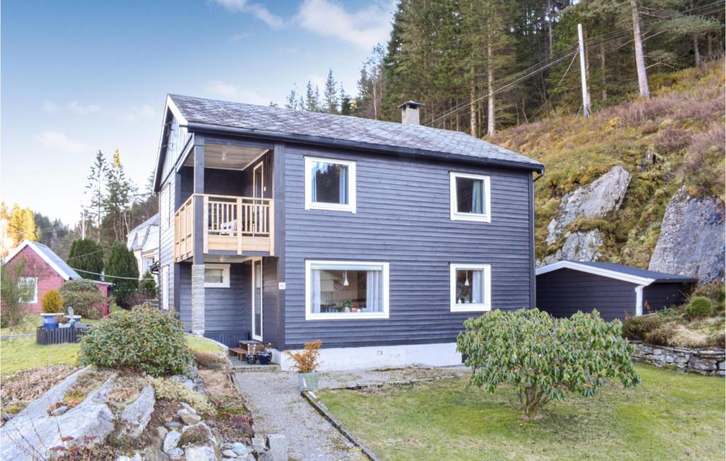 uma casa azul com uma varanda numa colina em Brten em Sanddal