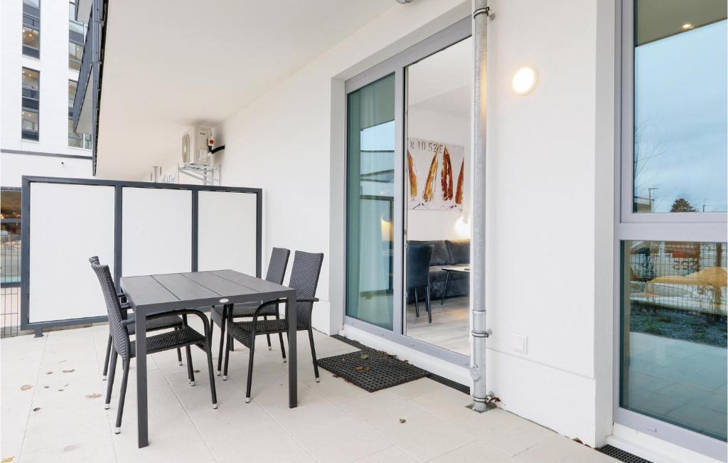 einen schwarzen Esstisch und Stühle auf dem Balkon in der Unterkunft Stunning Apartment In Lbeck Travemnde With 1 Bedrooms And Wifi in Travemünde