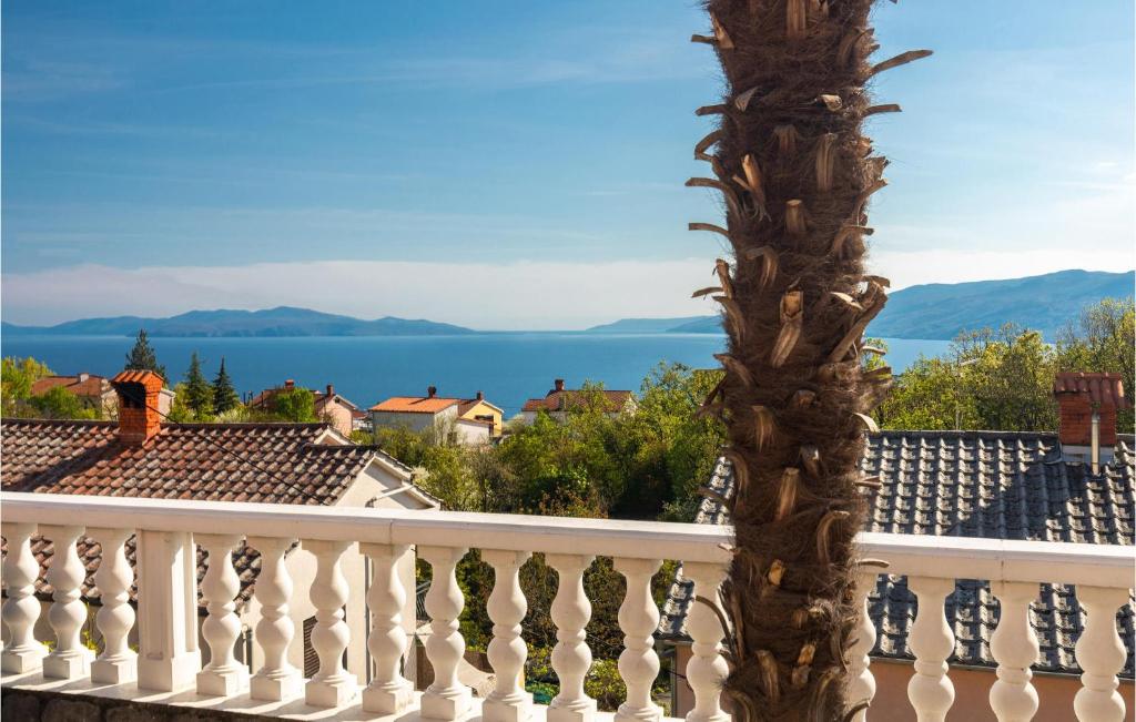 een uitzicht vanaf het balkon van een huis met een palmboom bij Beautiful Apartment In Rijeka With House A Panoramic View in Rijeka